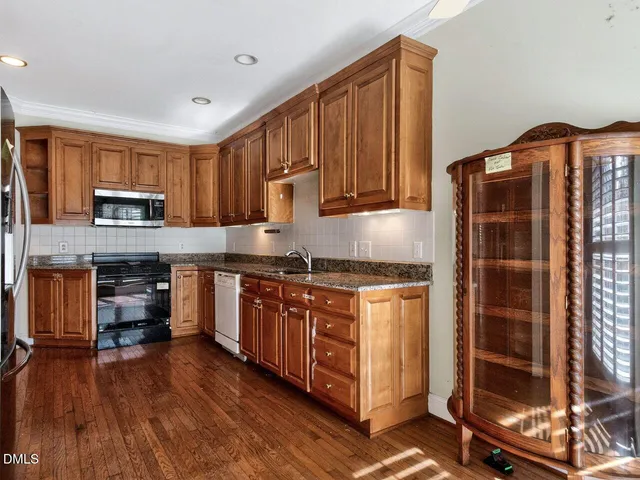 a kitchen with stainless steel appliances granite countertop a stove a sink and a refrigerator