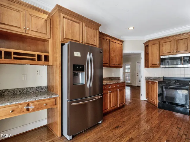 a kitchen with granite countertop stainless steel appliances and wooden cabinets