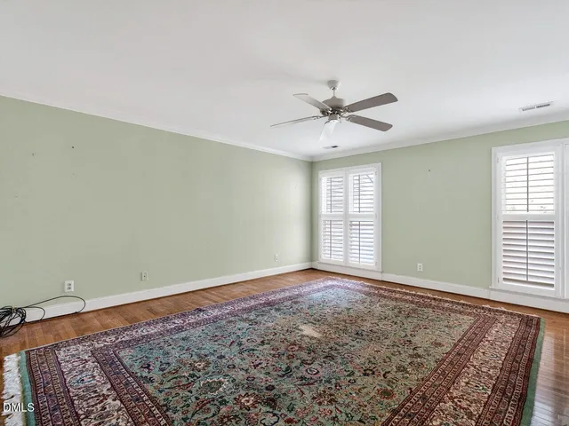 a view of a big room with windows and chandelier fan