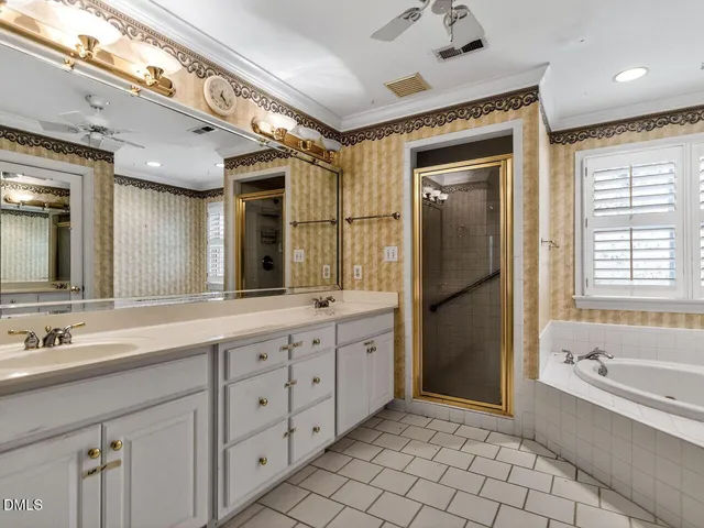 a spacious bathroom with a double vanity sink mirror and bathtub