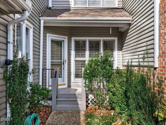 a front view of a house with plants and garden