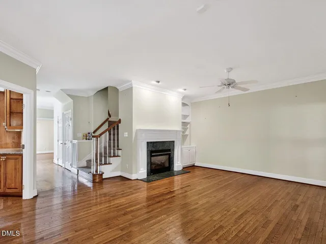 a view of empty room with wooden floor and fireplace