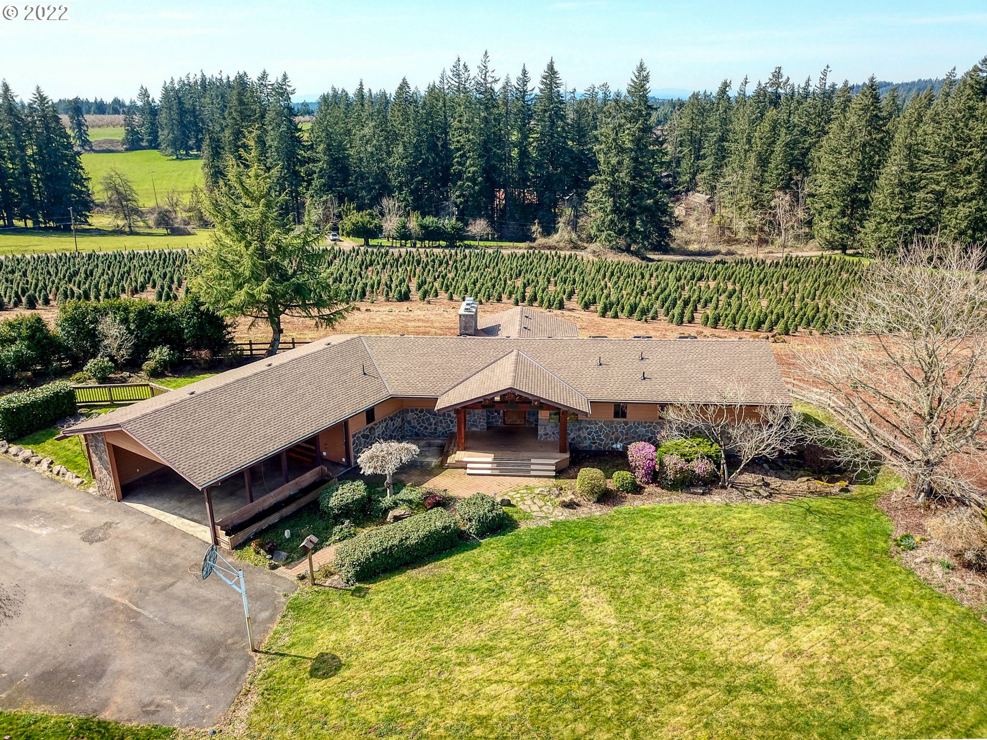 25861 South Larkin Road Beavercreek, OR 97004 - Photo 2 of 32 an aerial view of a house with garden space and trees in the background