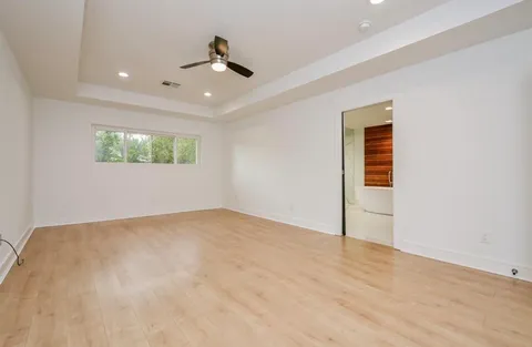 a view of an empty room with windows and a ceiling fan