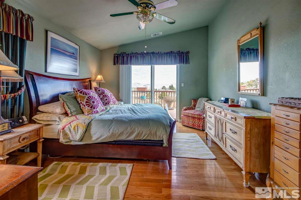 712 Talus Way Reno, NV 89503 - Photo 10 of 25 a spacious bedroom with a bed and a chandelier