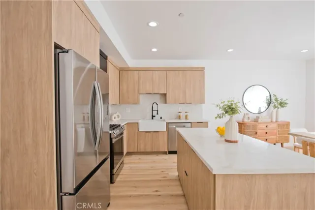 a kitchen with stainless steel appliances a refrigerator sink and stove