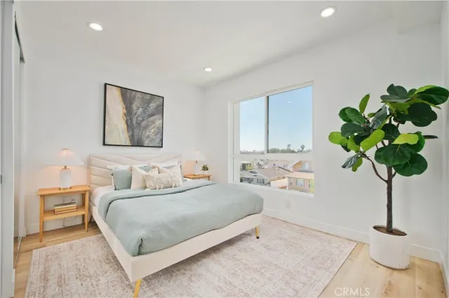 a bedroom with a bed a plant and a window