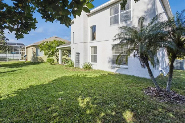 a view of a white house with a big yard and potted plants