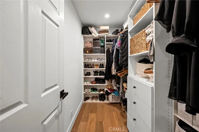 a view of walk in closet with clothes and shoes