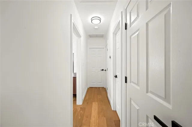 a view of a hallway with wooden floor and staircase