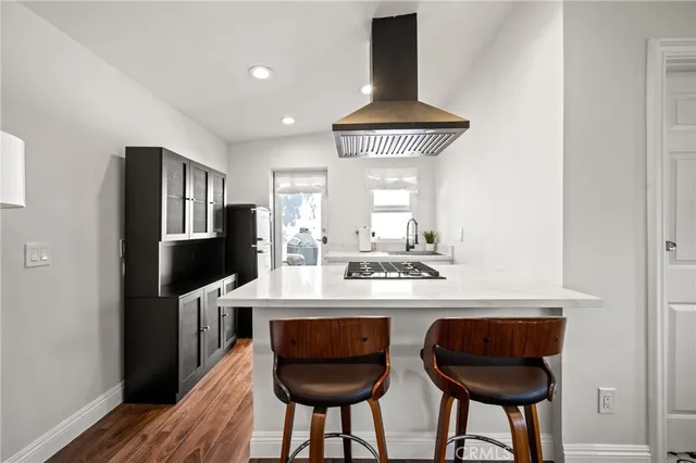 a kitchen with stainless steel appliances a dining table and chairs