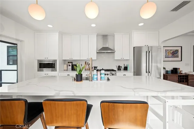a kitchen with stainless steel appliances granite countertop a sink and a refrigerator