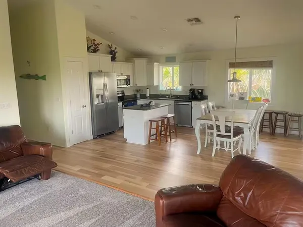 a living room with furniture wooden floor and a dining table