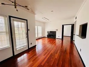 a view of empty room with wooden floor and fireplace