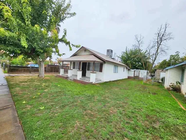 a front view of a house with a garden and yard