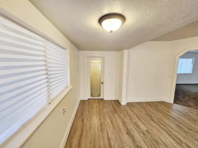 a view of a room with wooden floor and window
