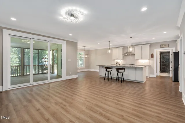 a view of a kitchen with a dining table chairs and floor to ceiling window