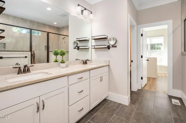 a bathroom with a double vanity sink a mirror and a shower