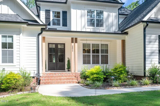 a kitchen with stainless steel appliances kitchen island granite countertop a refrigerator a stove a sink dishwasher and a dining table with wooden floor