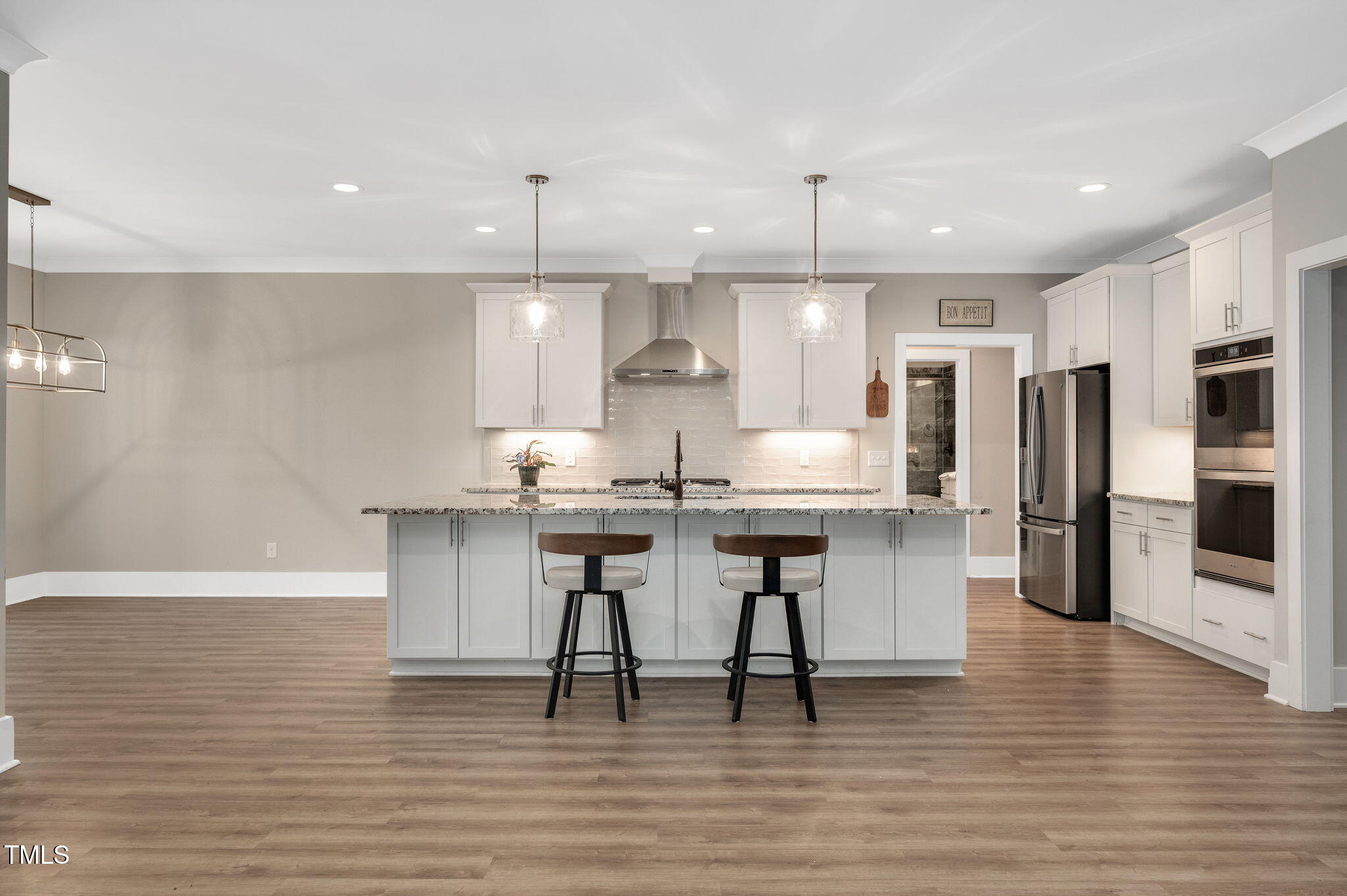 3511 Bruce Garner Road Wake Forest, NC 27587 - Photo 6 of 46 a kitchen with stainless steel appliances granite countertop a stove a sink dishwasher a refrigerator and a dining table with wooden floor