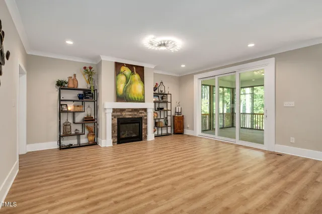 a view of an empty room with a fireplace and a window