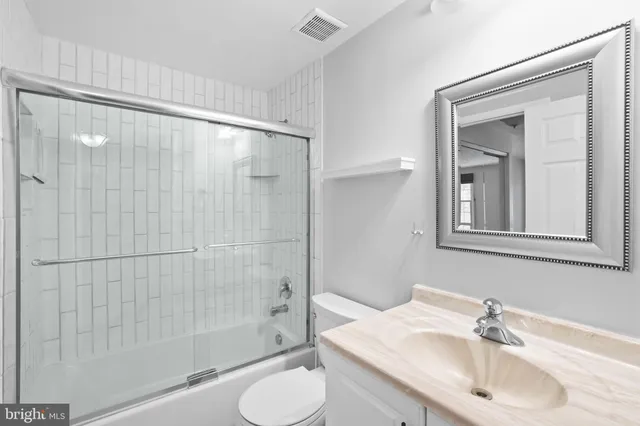 a bathroom with a sink and mirror with toilet