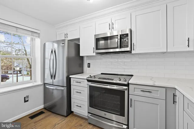 a kitchen with stainless steel appliances granite countertop a refrigerator and a stove top oven