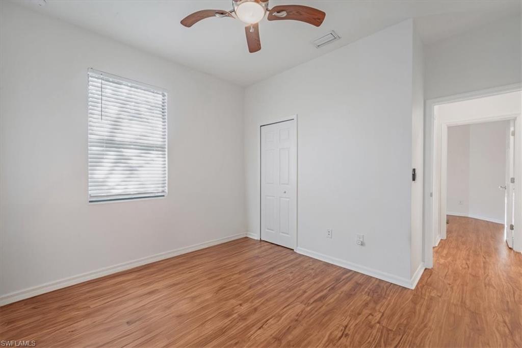 9052 Glenforest Drive Naples, FL 34120 - Photo 12 of 20 wooden floor in an empty room with a window