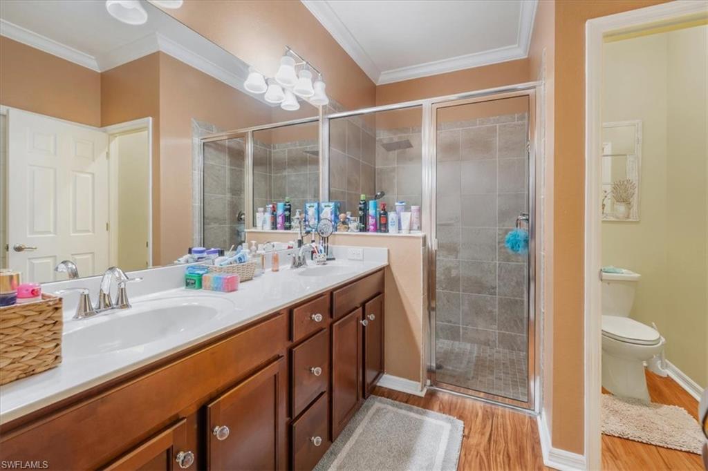 9052 Glenforest Drive Naples, FL 34120 - Photo 15 of 20 a bathroom with a double vanity sink toilet and shower