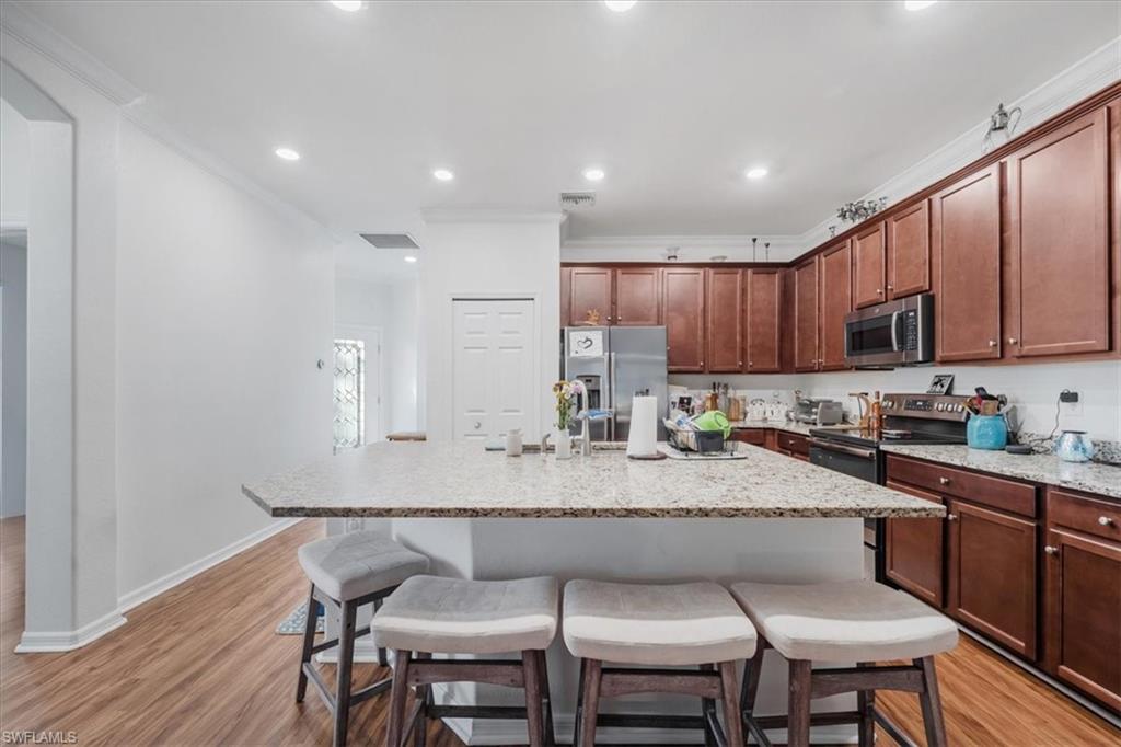 9052 Glenforest Drive Naples, FL 34120 - Photo 6 of 20 a large kitchen with kitchen island a dining table and chairs