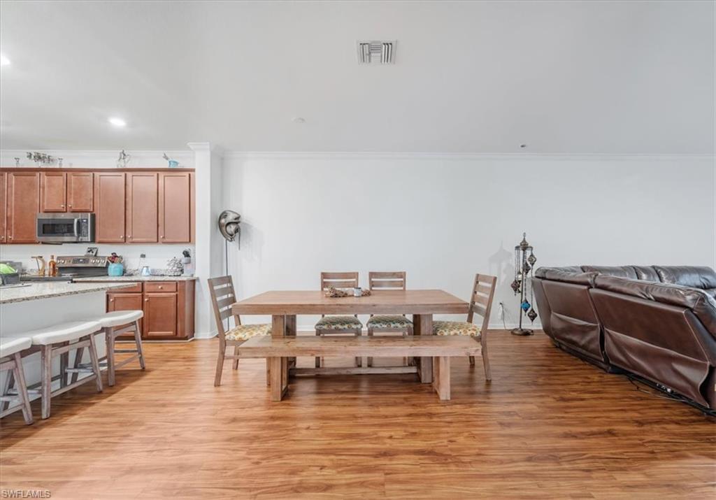 9052 Glenforest Drive Naples, FL 34120 - Photo 9 of 20 a living room with stainless steel appliances kitchen island granite countertop a stove a sink a refrigerator and cabinets