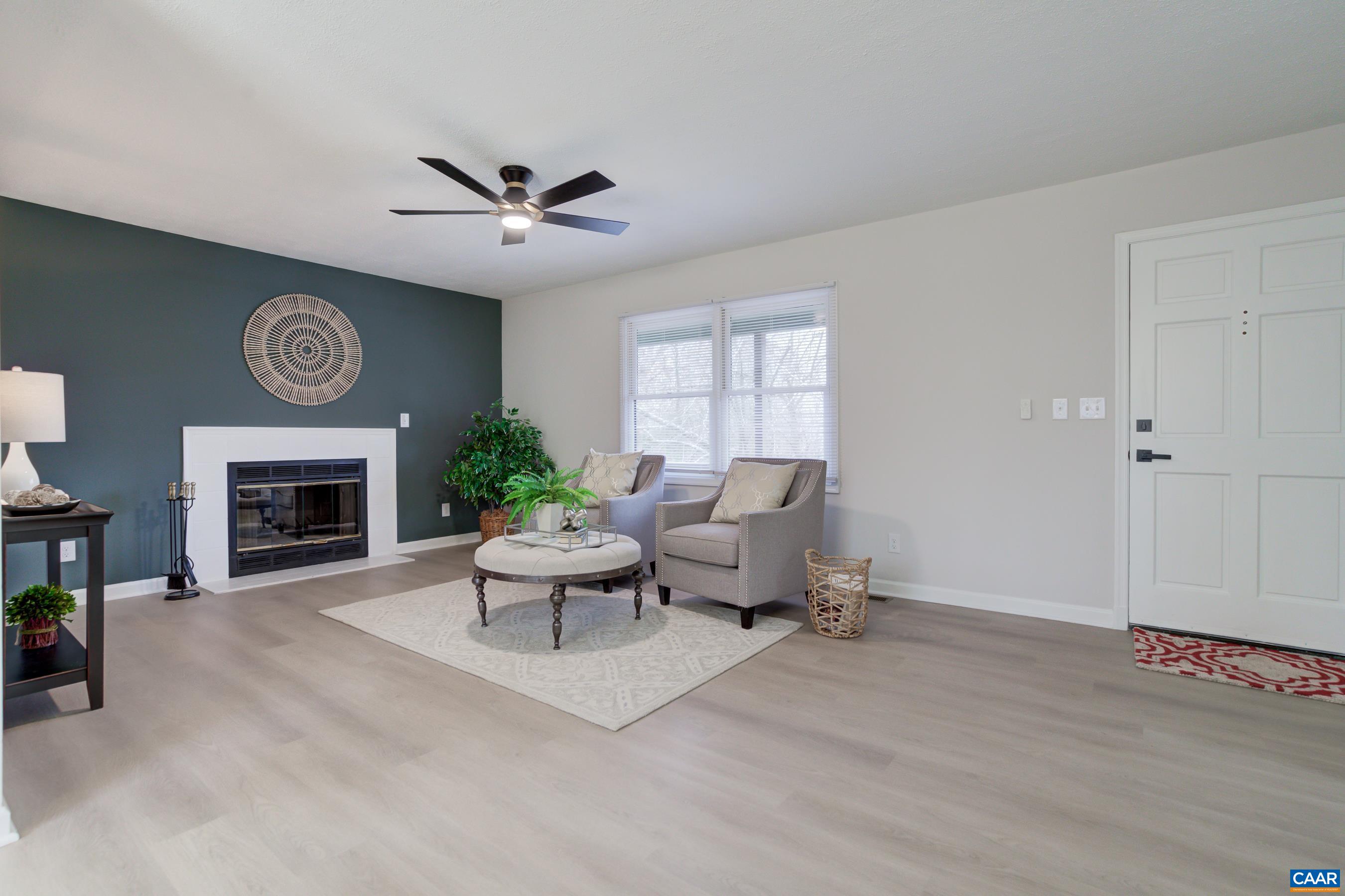 5582 Brookwood Road Crozet, VA 22932 - Photo 9 of 61 a living room with furniture a clock and a fireplace