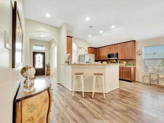a kitchen with stainless steel appliances kitchen island granite countertop a stove a sink and a refrigerator