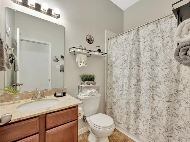 a bathroom with a granite countertop sink toilet and shower