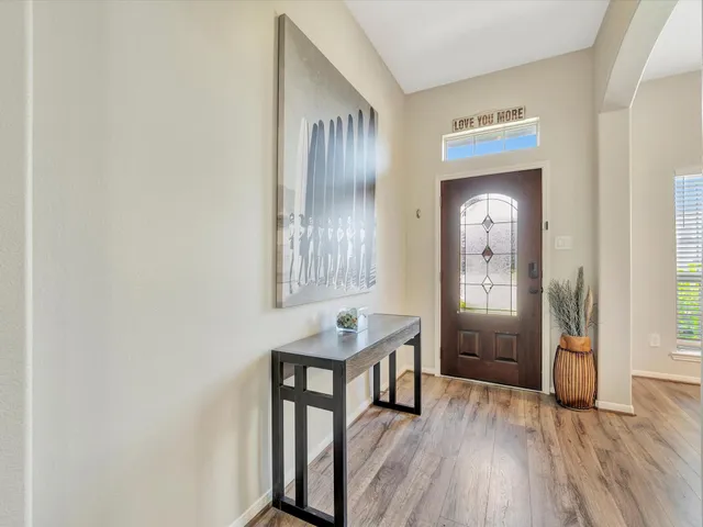 a view of a hallway with wooden floor and furniture