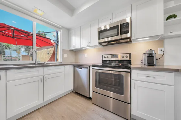 a kitchen with stainless steel appliances granite countertop a stove a microwave and a sink