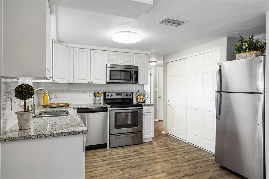 7215 Mayfield Drive Port Richey, FL 34668 - Photo 27 of 52 a kitchen with granite countertop a refrigerator stove and microwave
