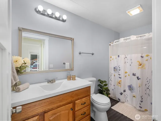 a bathroom with a granite countertop sink a toilet and a mirror