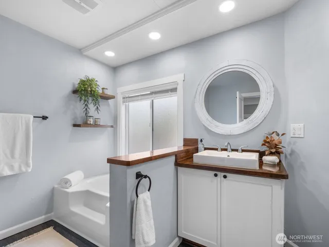 a bathroom with a sink mirror and vanity