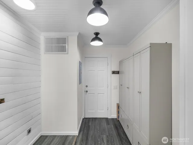 a view of a hallway with wooden floor and a bathroom