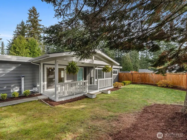 a view of a house with a yard balcony and wooden fence