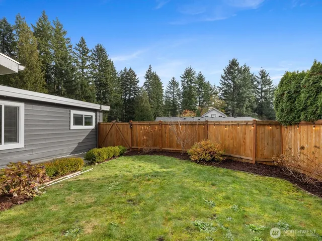 a view of a backyard with potted plants and wooden fence