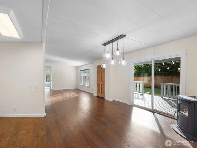 an empty room with wooden floor and outdoor view