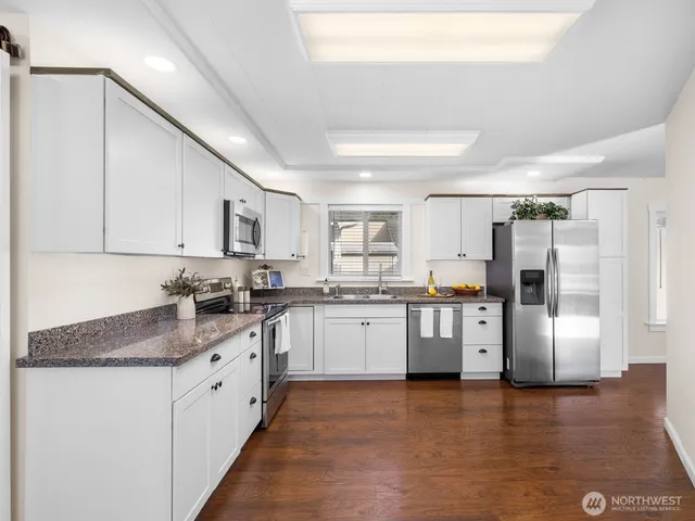 a kitchen with stainless steel appliances granite countertop a refrigerator sink and cabinets