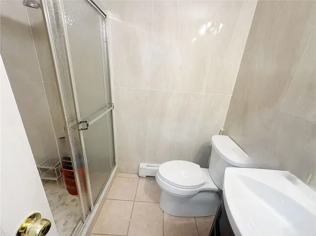 a white toilet sitting next to a shower