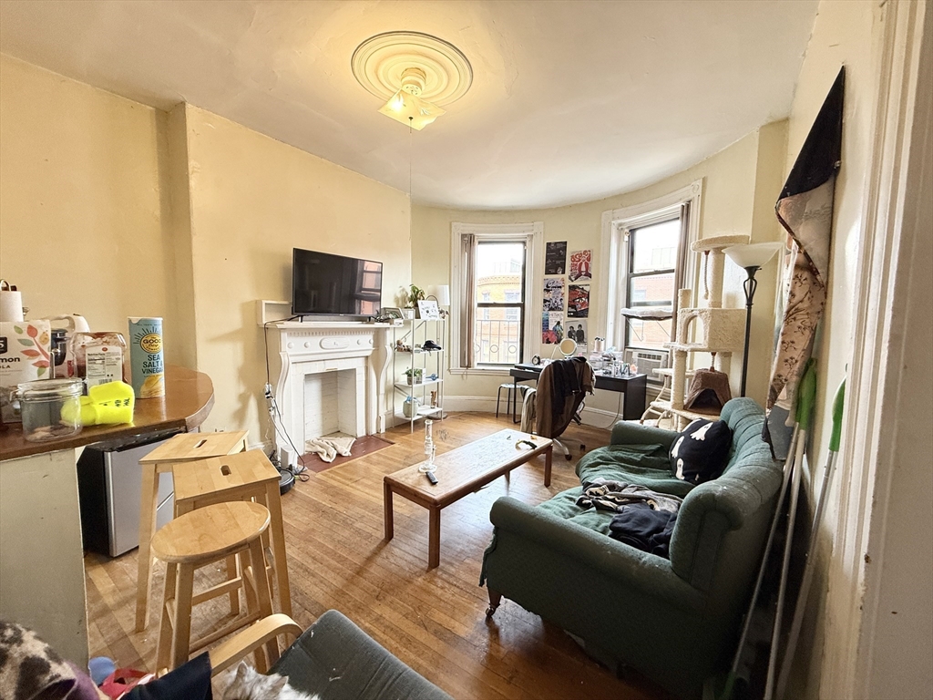 26 Symphony Road, Unit 4 Boston, MA 02115 - Photo 3 of 7 a living room with furniture a fireplace and a flat screen tv