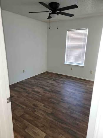 261 Audrey Avenue Waco, TX 76705 - Photo 10 of 11 an empty room with wooden floor fan and windows