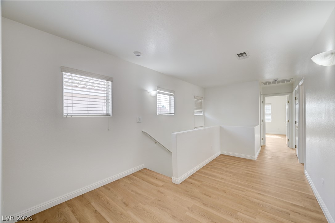 8918 Houston Ridge Avenue Las Vegas, NV 89178 - Photo 13 of 35 Sun-filled hallway featuring light wood flooring and well-placed windows.