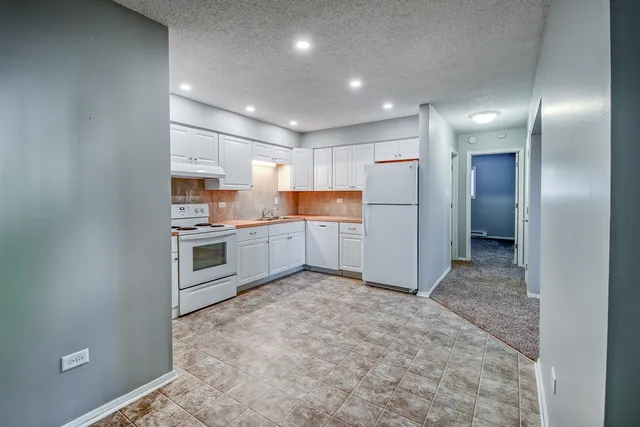 a view of a kitchen with a sink and dishwasher a refrigerator