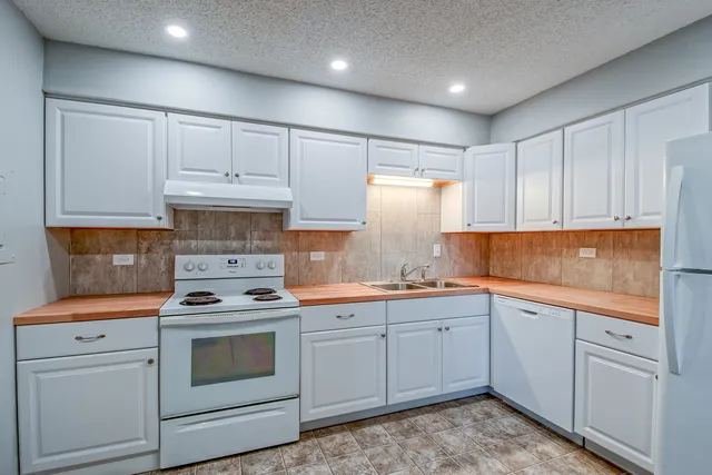 a kitchen with cabinets appliances and a sink